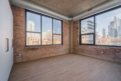 A room with a brick wall and wooden floor.