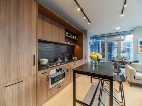a kitchen with wooden cabinets and a table with stools