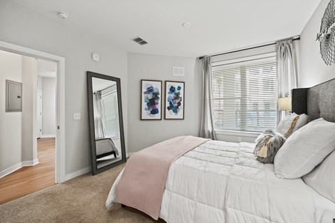 A bedroom with a large bed and a mirror on the wall.