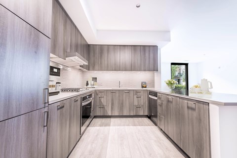 A modern kitchen with wooden cabinets and a white countertop.