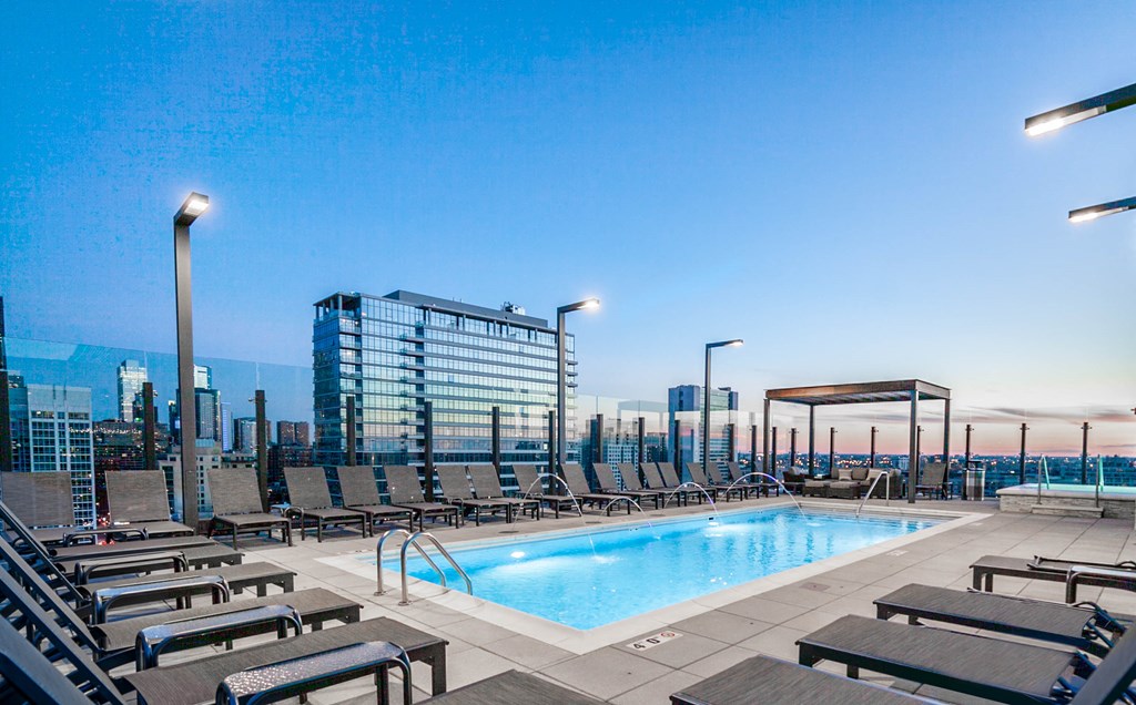 a swimming pool on the rooftop of a building with a city in the background