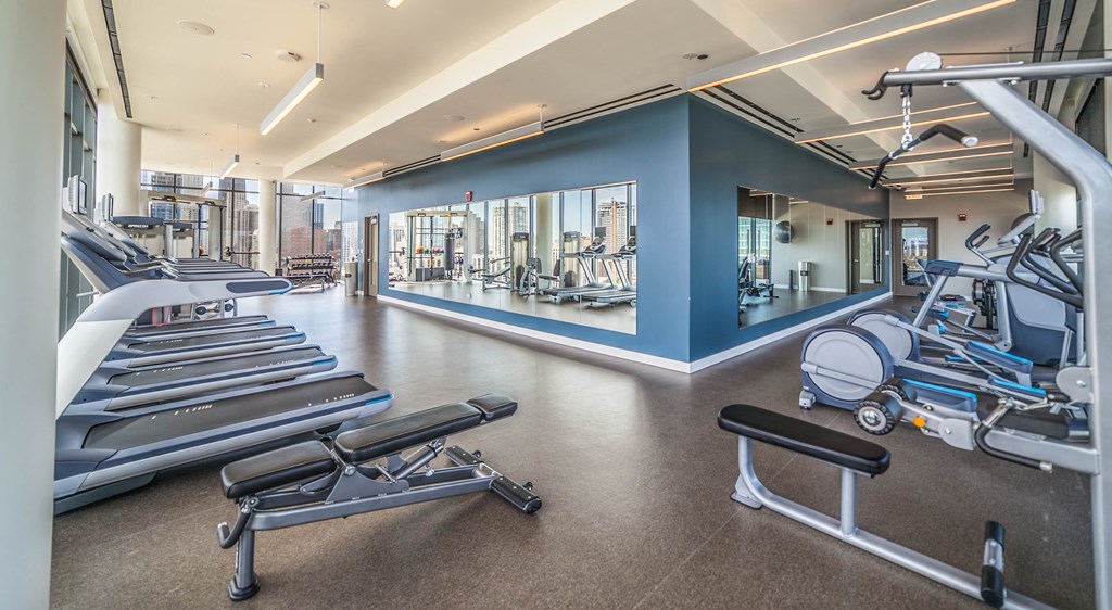 Fitness center with treadmills, ellipticals, and benches