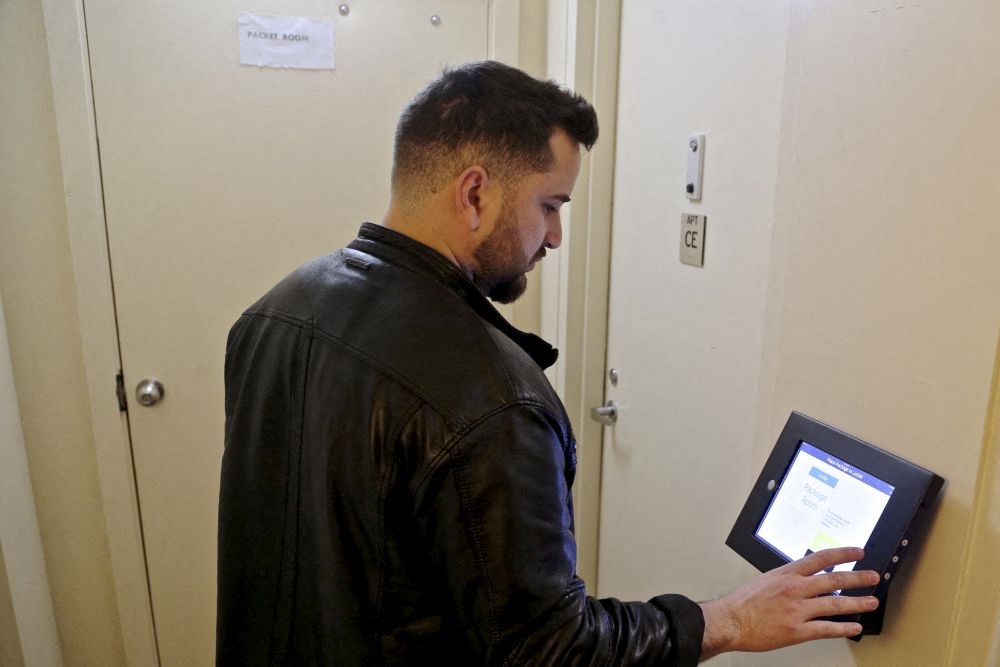 a man holding an ipad in front of a door