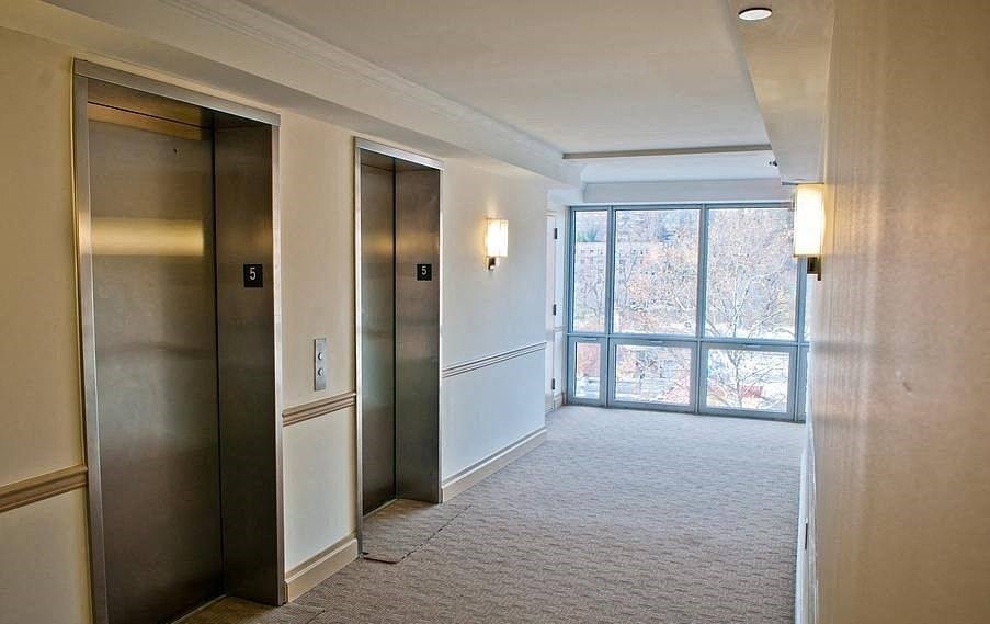 a empty hallway with three doors and a window