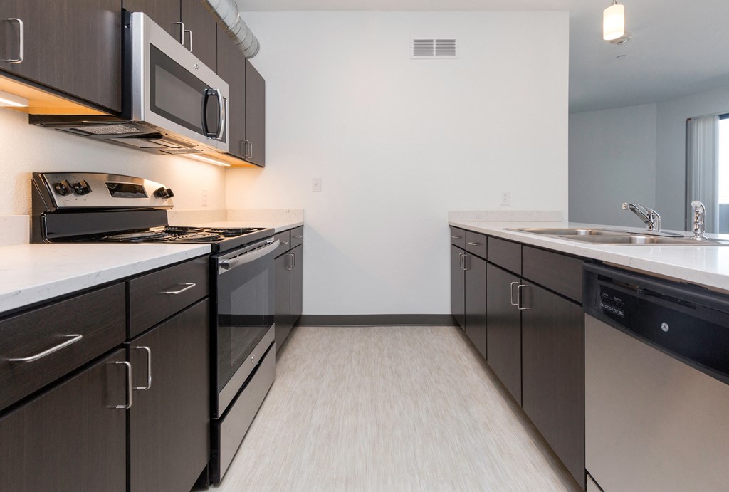 a kitchen with stainless steel appliances and a sink and a microwave