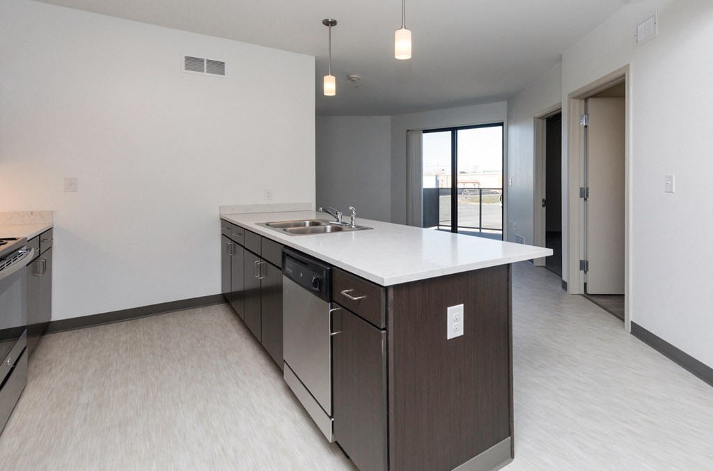 a kitchen with an island and a sink in a new home