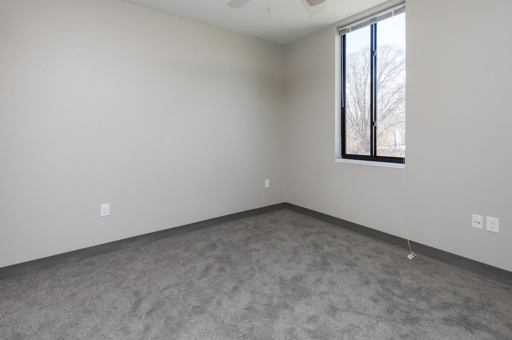 an empty room with a window and a carpet