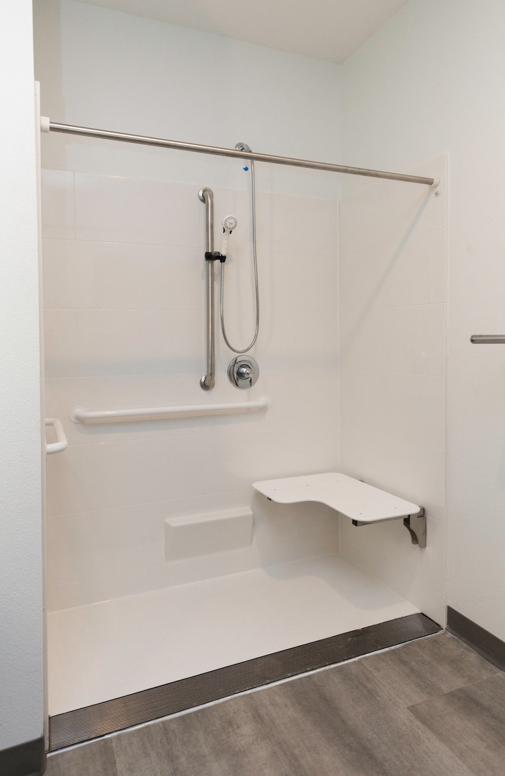 a bathroom with a shower and a stool in it