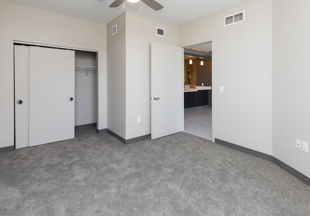 an empty living room with white walls and a ceiling fan