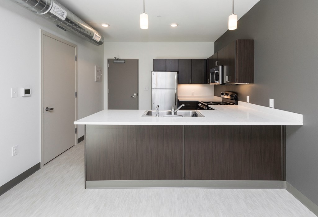 a kitchen with a white counter top and a refrigerator