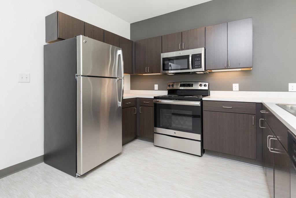 a kitchen with stainless steel appliances and dark wood cabinets