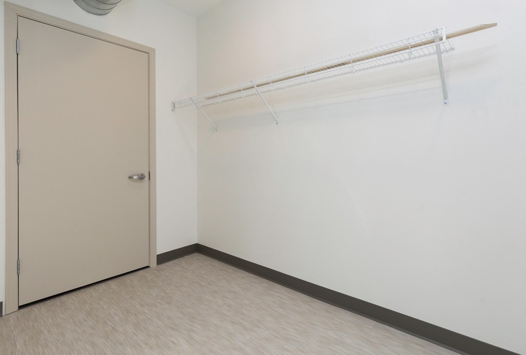an empty room with a white door and a white wall with a closet and a