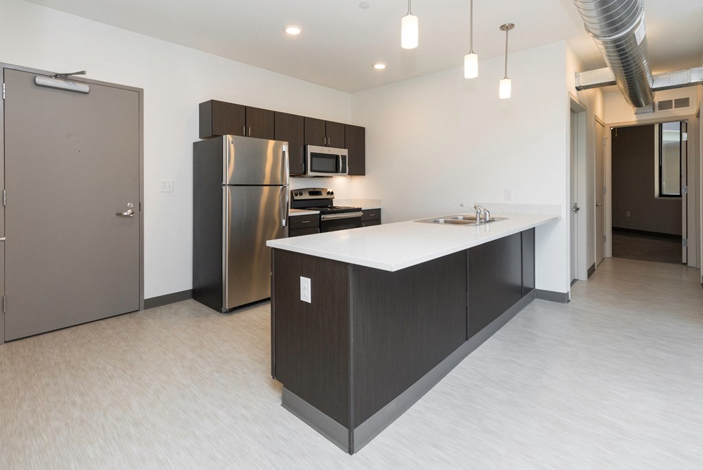 a kitchen with an island and a stainless steel refrigerator