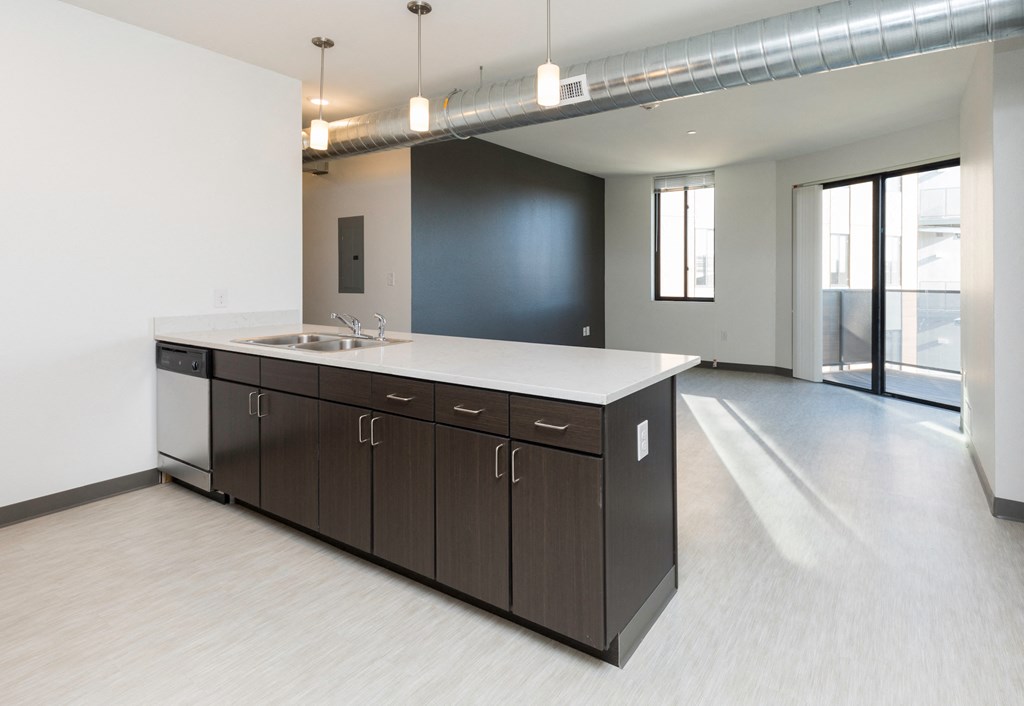 an empty kitchen with a sink and a counter top in a building