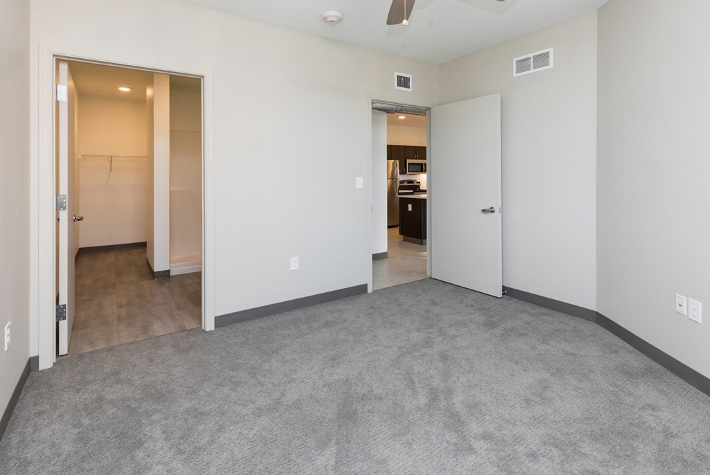 an empty living room with white walls and a gray carpet