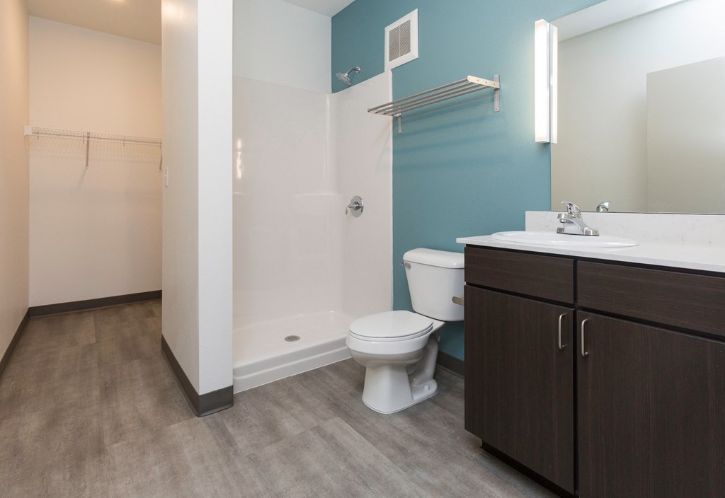 a bathroom with a toilet sink and shower and a mirror