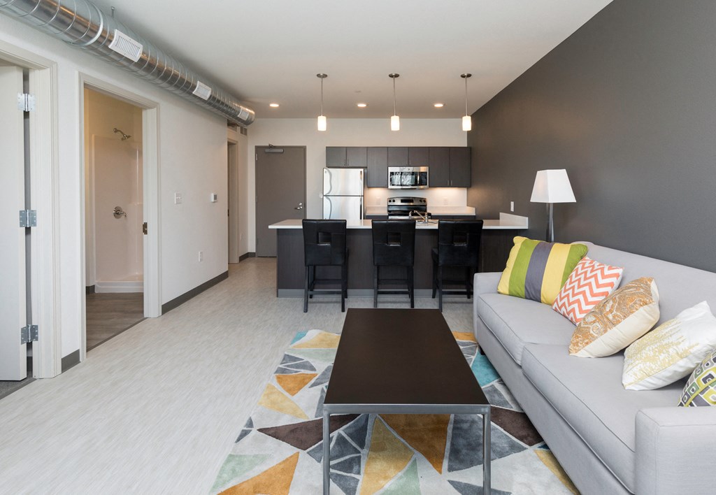 a living room and kitchen with a couch and a table
