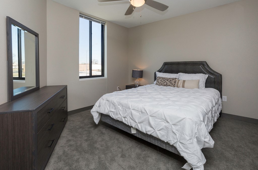 a bedroom with a bed and a dresser and a window