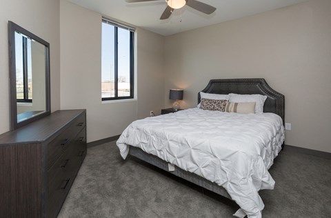 Bright, vacant bedroom with neutral walls and carpet flooring.
