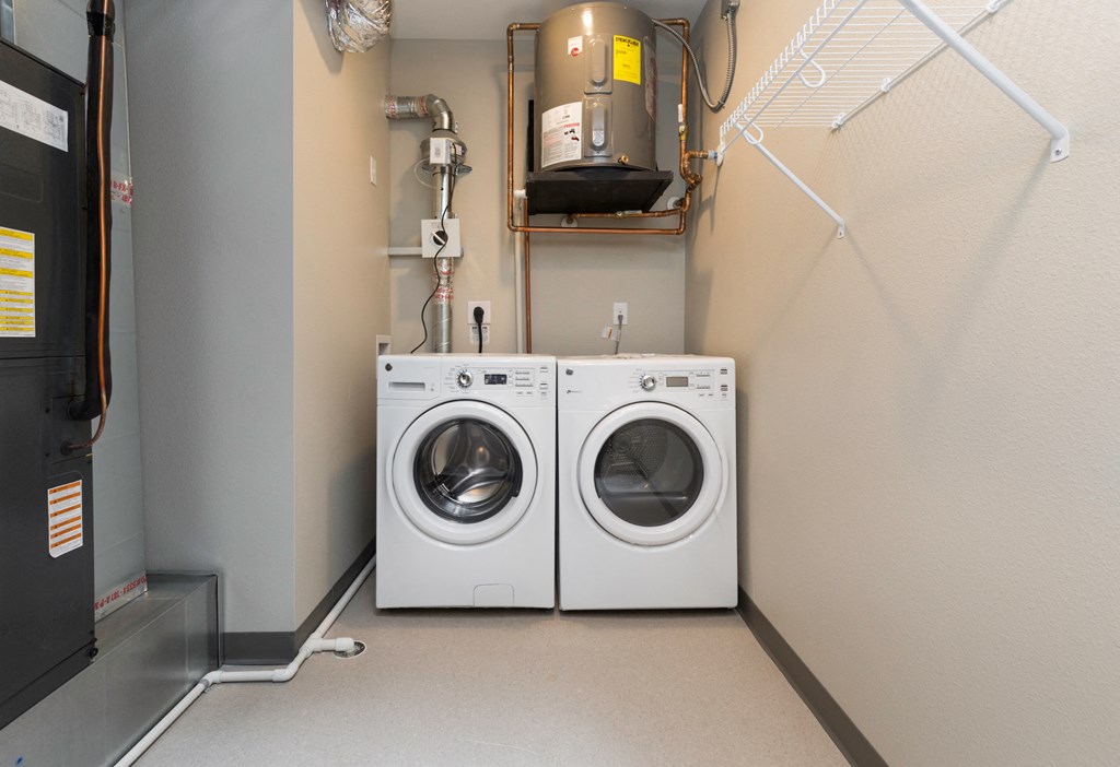 a washer and dryer in a room with a boiler and a dryer