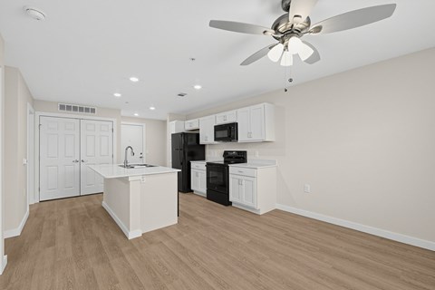 A kitchen with a white island and black appliances.