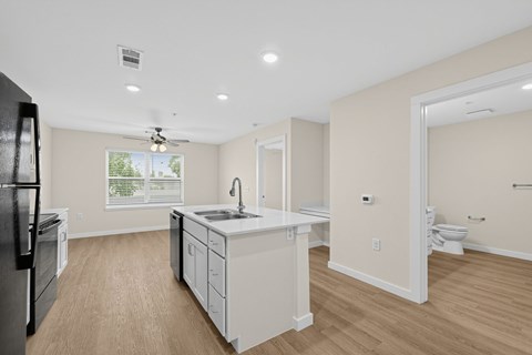 A kitchen with a refrigerator, sink, and cabinets.