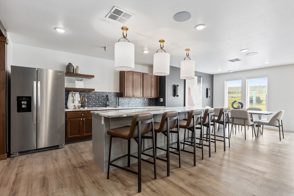 an open kitchen and dining area with a large island and chairs