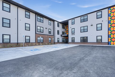 A parking lot in front of a building with the number 202 on it.