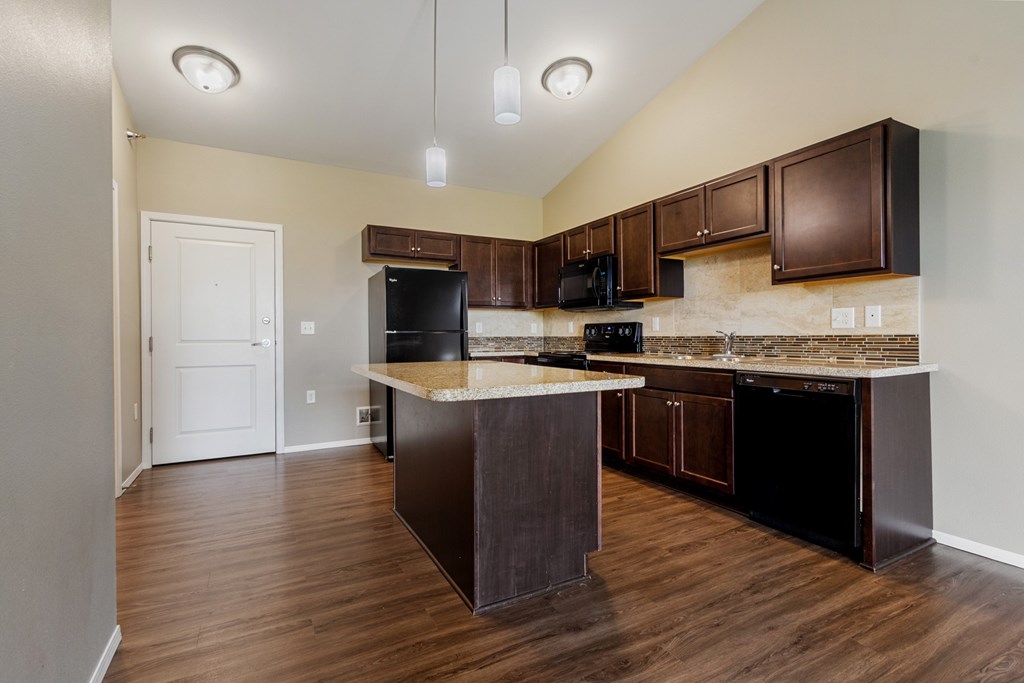 A kitchen with dark wood cabinets and a white countertop.