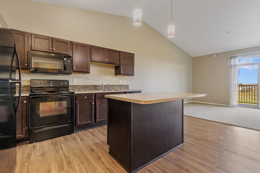 A kitchen with dark wood cabinets and appliances.