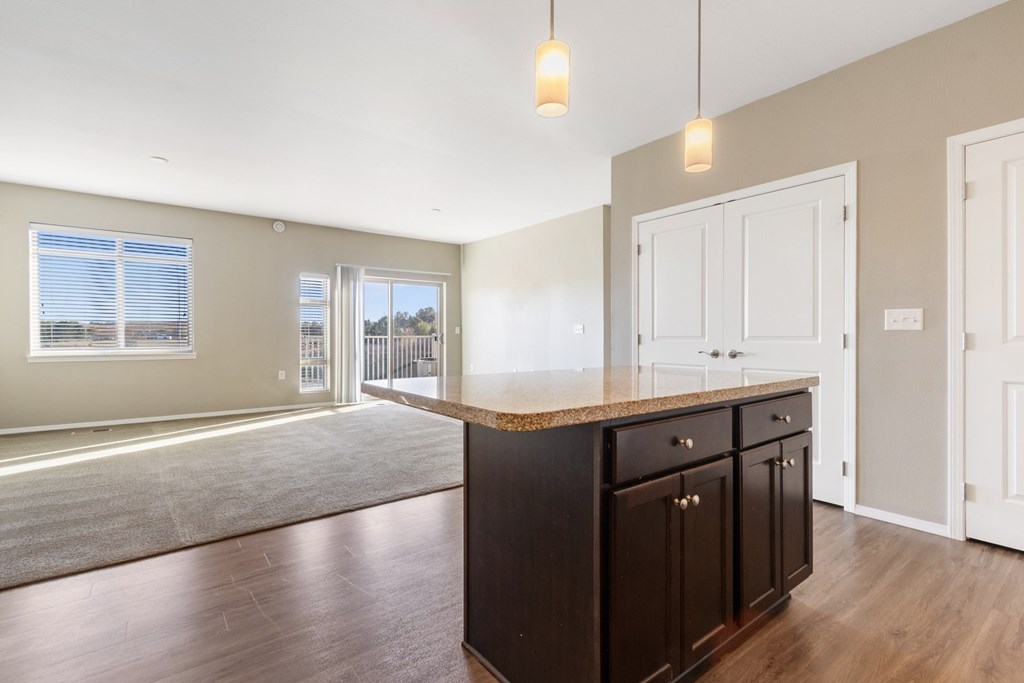 A kitchen with a brown counter top and cabinets.