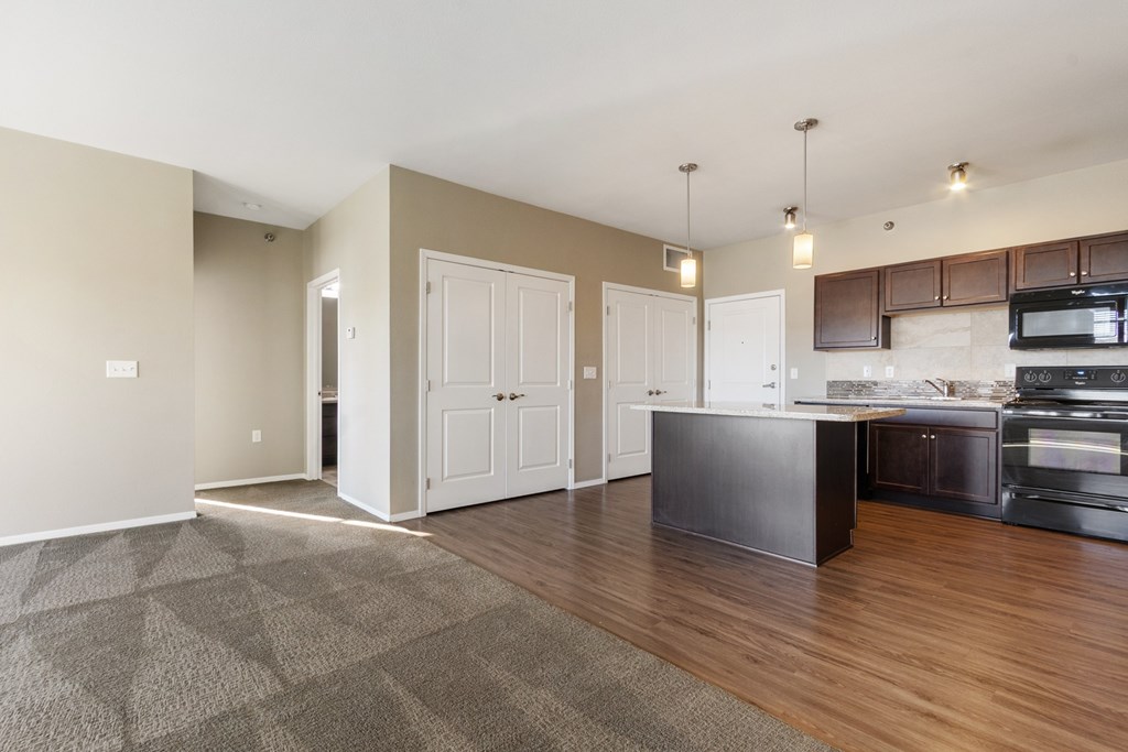 A kitchen with a black counter top and white cabinets.