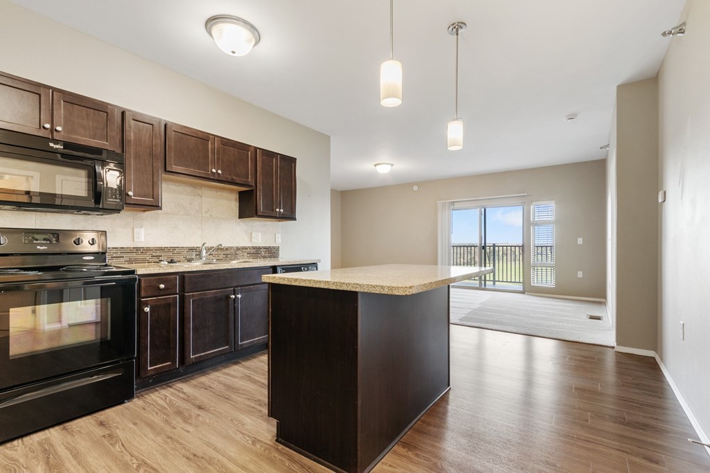 A kitchen with dark wood cabinets and a black oven.