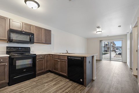 A kitchen with wooden cabinets and black appliances.