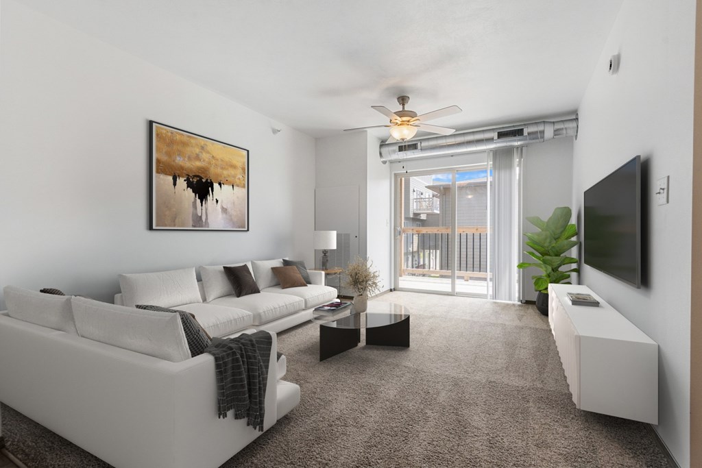 A living room with a white couch and a painting on the wall.