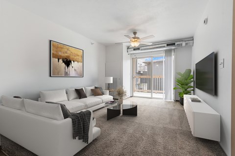 A living room with a white couch and a painting on the wall.