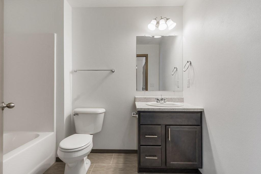 A white toilet sits next to a sink in a bathroom.