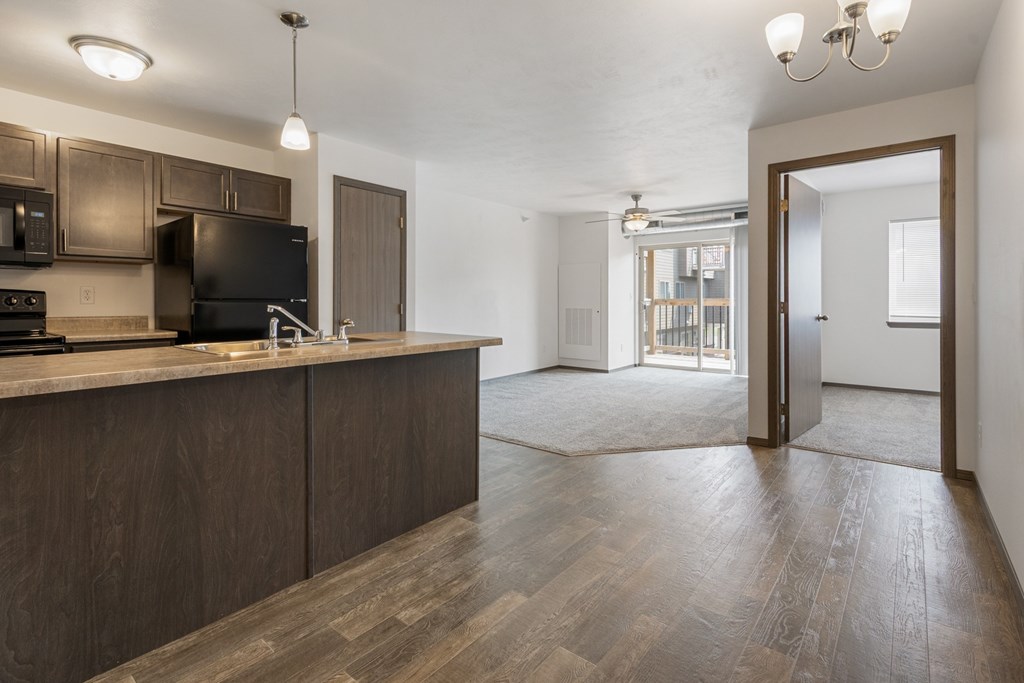 A kitchen with dark wood cabinets and a black stove top oven.