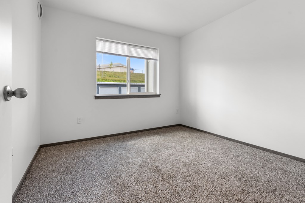 A room with a window overlooking a building outside.