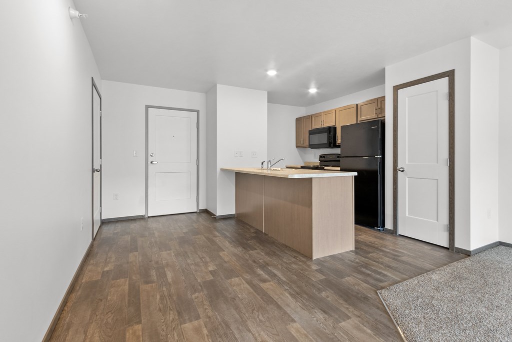 A kitchen with a wooden floor and white walls.
