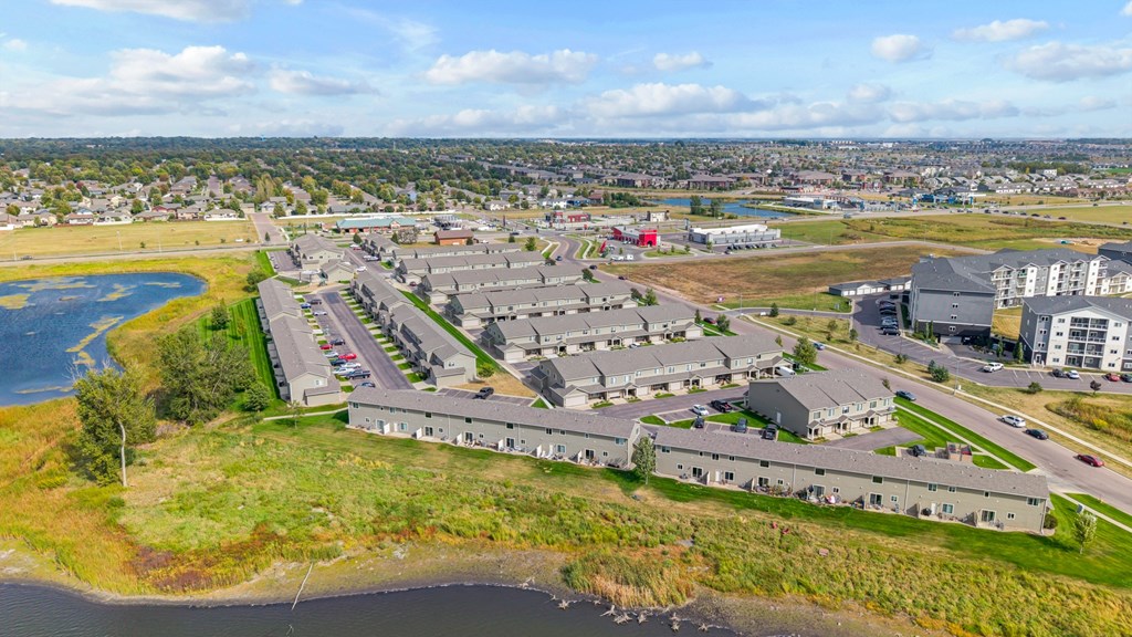 A bird's eye view of a large building complex with a body of water in the foreground.