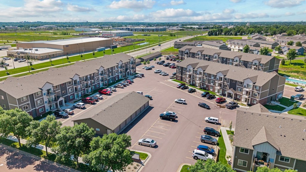 A large parking lot is surrounded by apartment buildings.