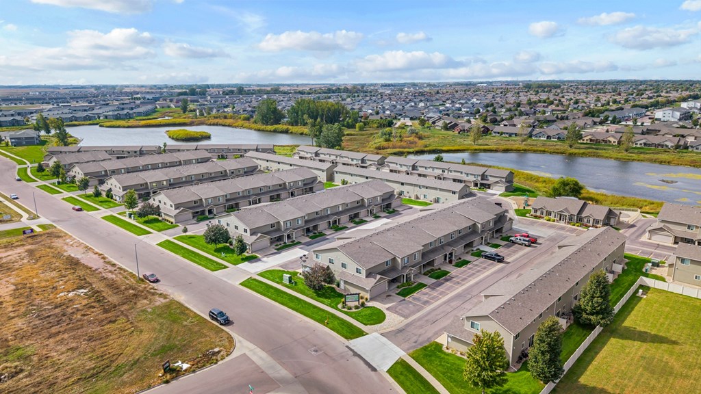 A large, modern housing complex with a lake in the background.