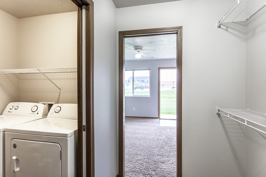 an empty laundry room with a washer and dryer in it and a closet