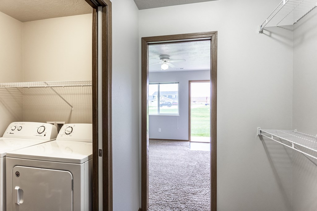 an empty laundry room with a washer and dryer in it and a closet