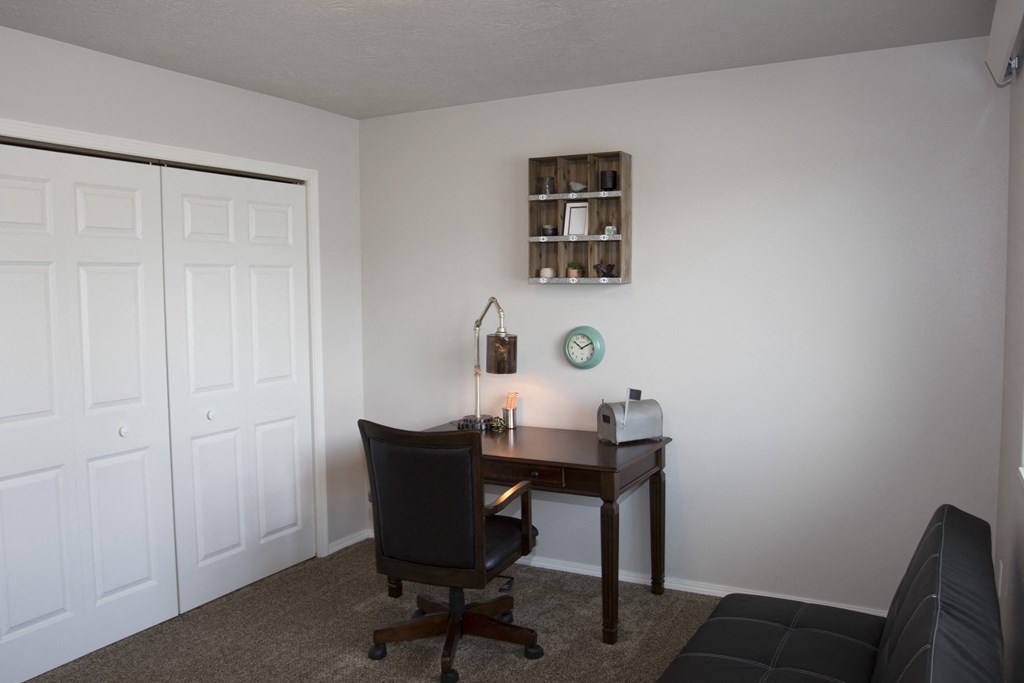a room with a desk and a chair and a couch