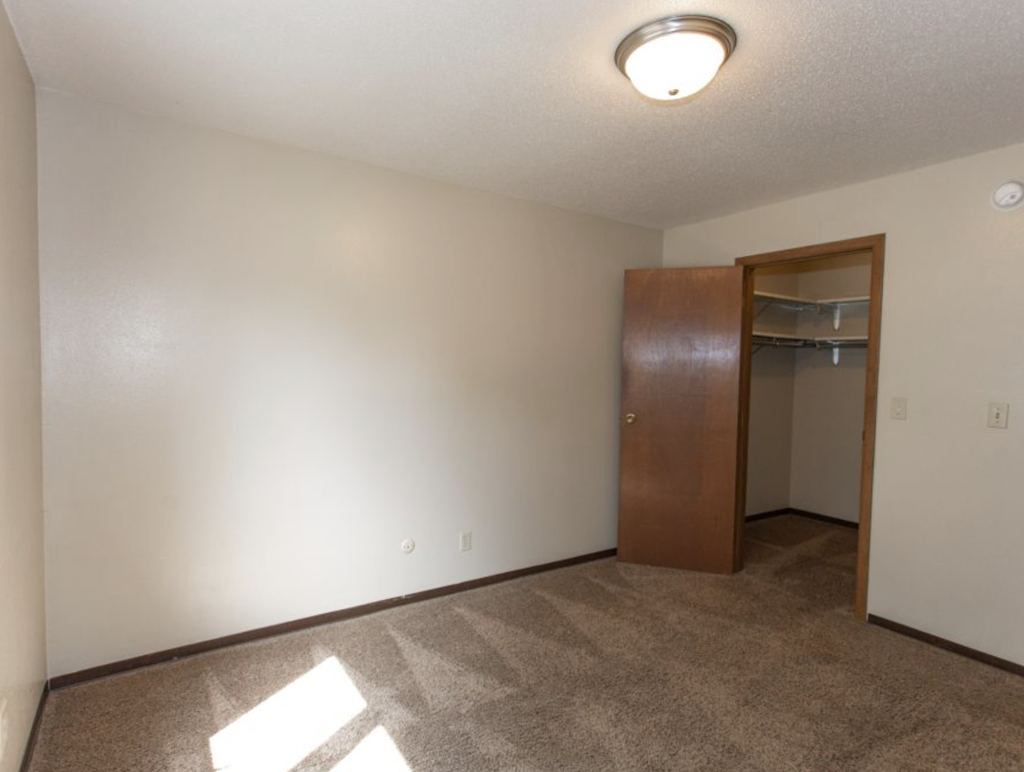 an empty living room with a closet and a door
