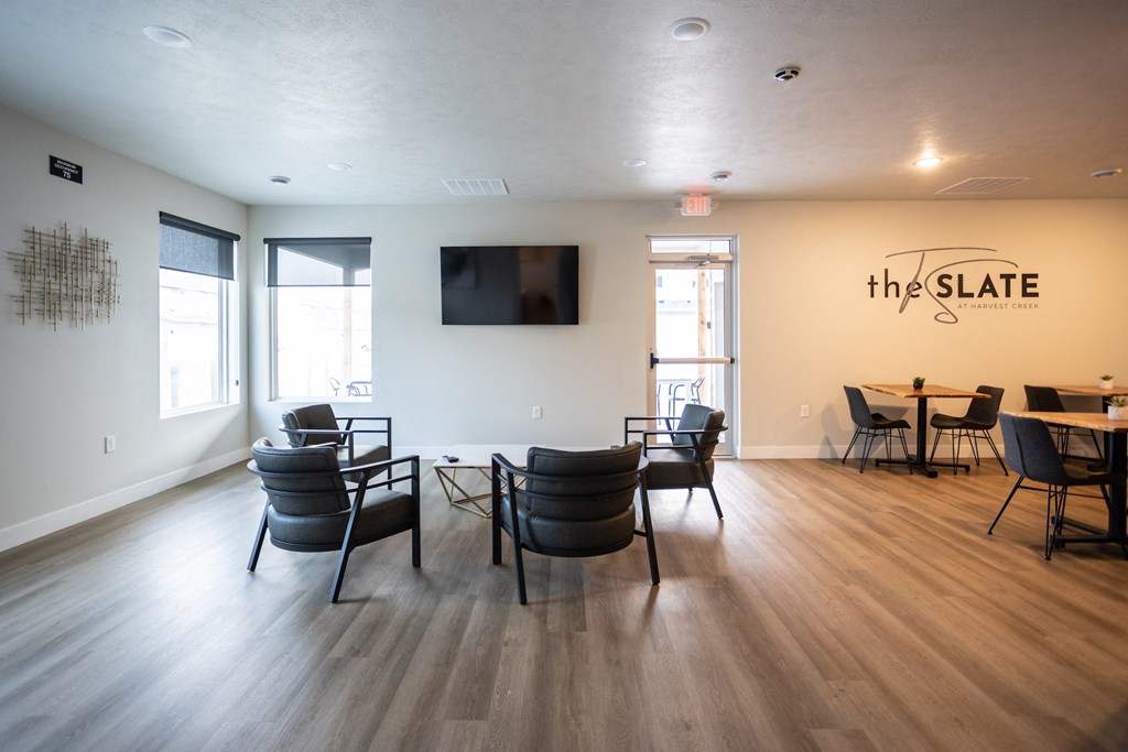 the slate common room with tables and chairs and a television