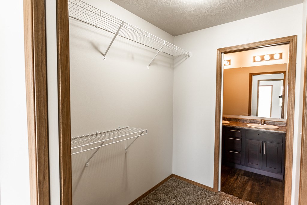 an empty closet in a bathroom with a mirror and a sink