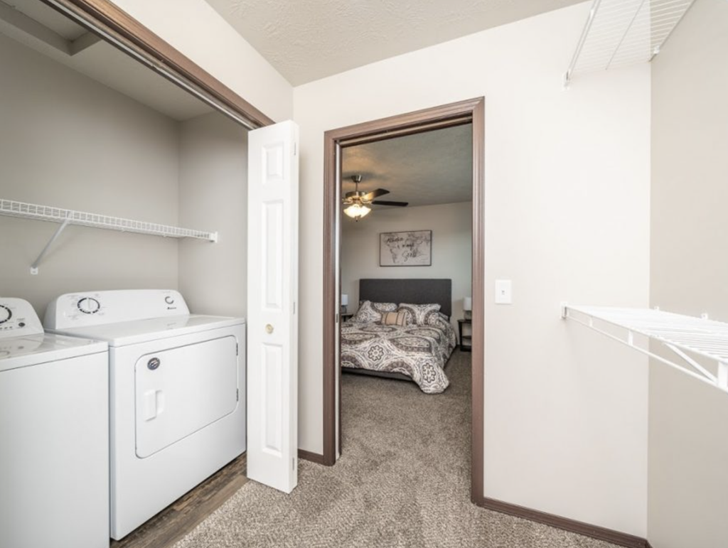 a washer and dryer in a room with a bedroom